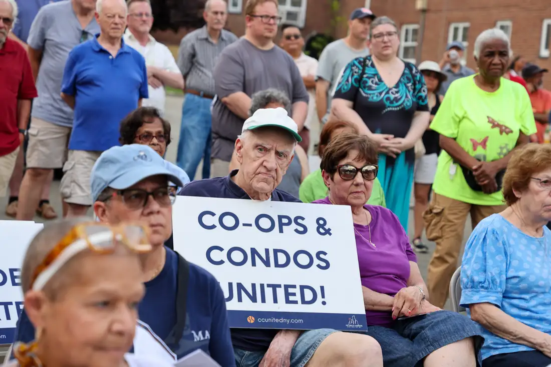 A dense crowd of residents at a rally holding Co-ops and Condos United signs